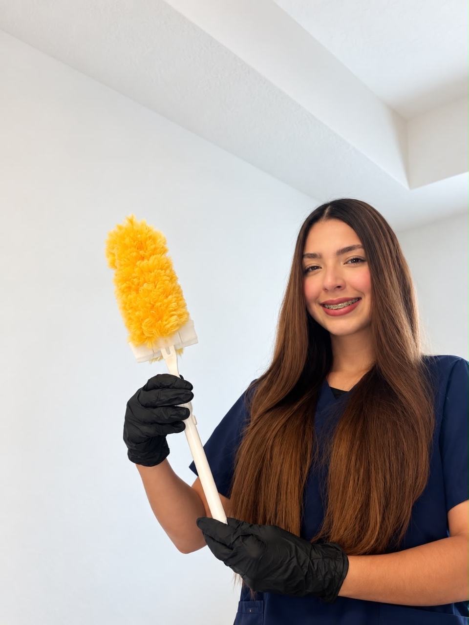 Anahys smiling in her navy uniform, black gloves and yellow duster